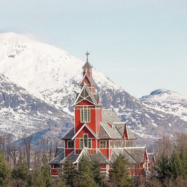 Red church among Norwegian mountains.