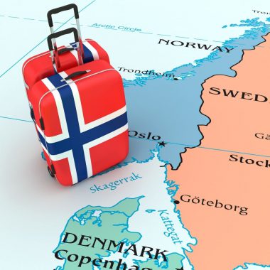 Walizka z kolorami flagi Norwegii na tle mapy Skandynawii.