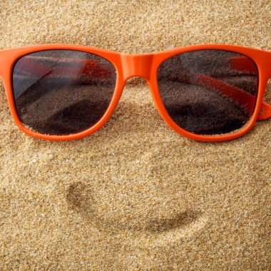 Et smilende ansikt i sanden.