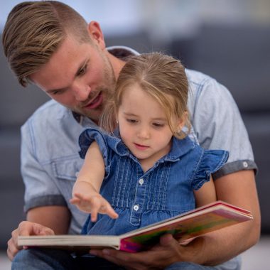Ojciec czytający książkę z córką.